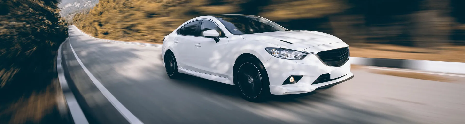 Witte auto rijdt overdat op een asfaltweg